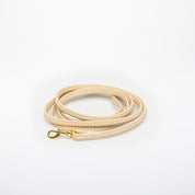 Correa para perro de color beige.